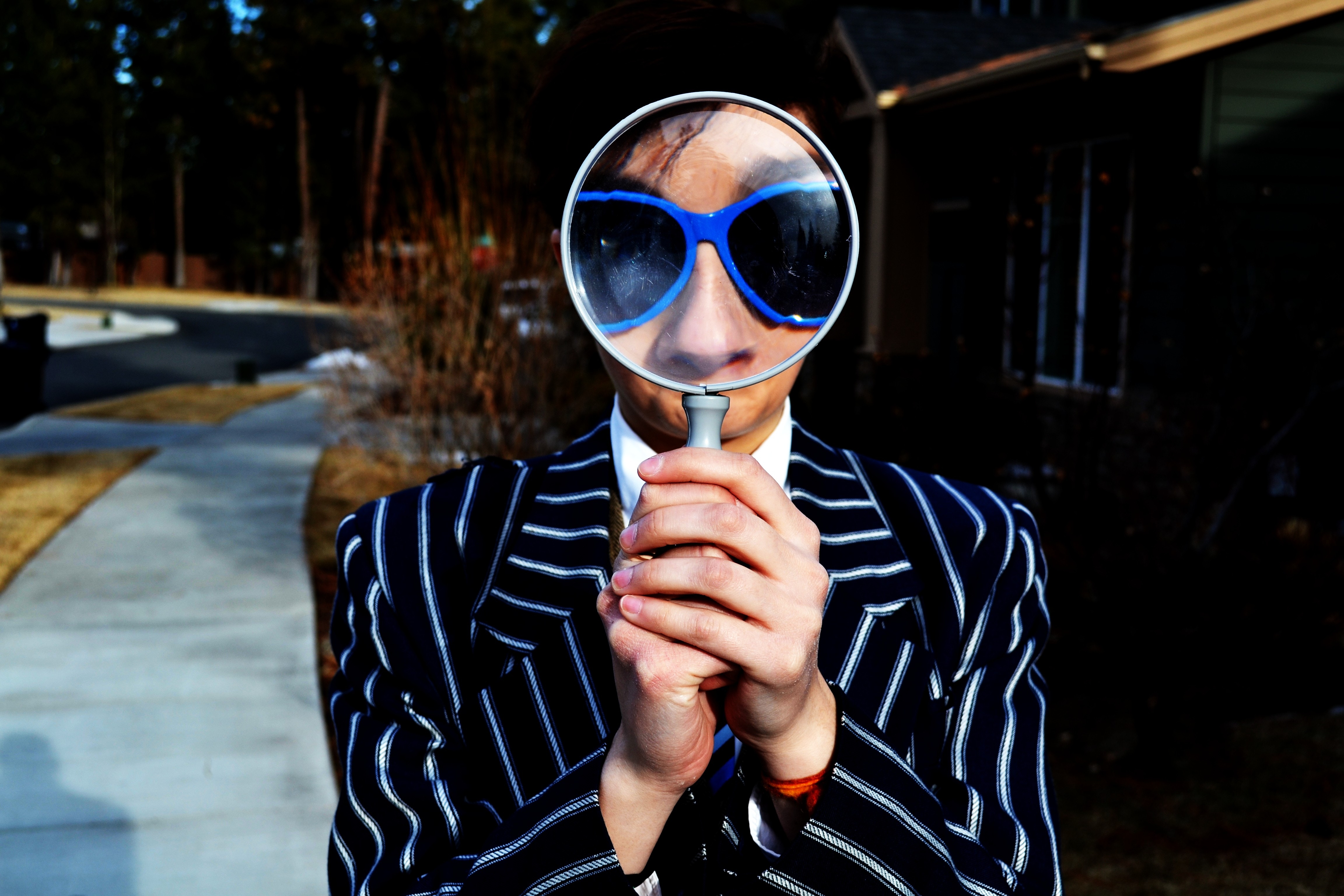 Person wearing sunglasses looking through a magnifying glass - SEO techniques for Content marketing