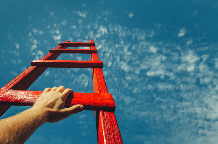 content marketing - a person climbing a ladder leading to the sky