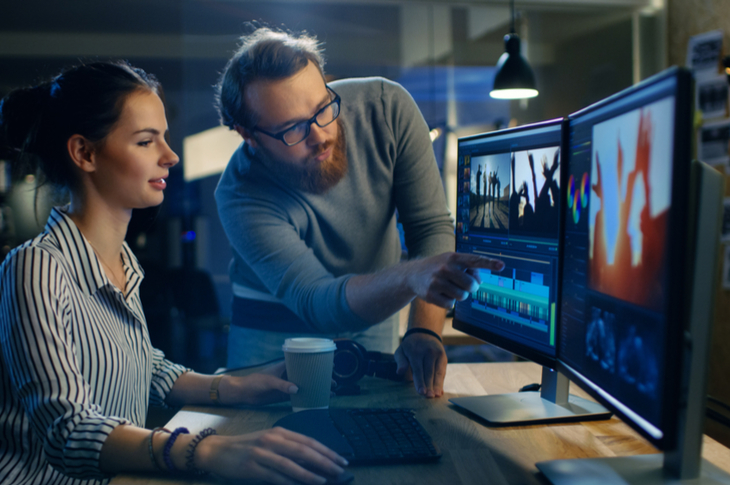 video editing - a man assisting a woman in editing a video