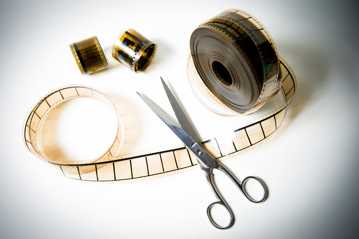 Editing Cuts - An image of a film reel with scissors - Scatter